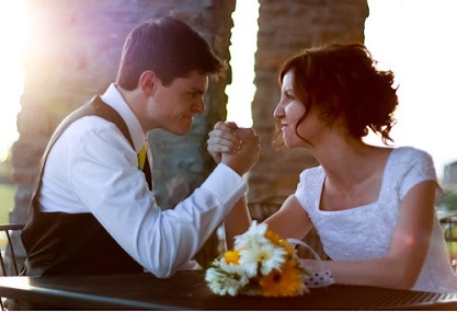 Bride and groom arm wrestle